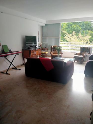 a living room with a couch and a television at Espace et sérénité in Netanya