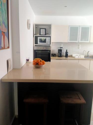 a kitchen with a bowl of oranges on a counter at Espace et sérénité in Netanya