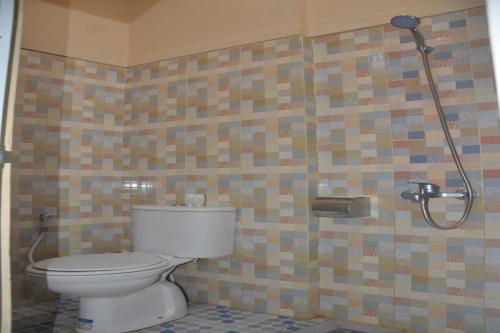 a bathroom with a toilet and a shower at OYO 93736 Homestay Joglo Dephis Syariah in Magelang
