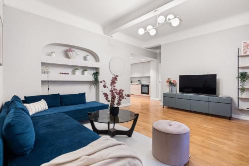 a living room with a blue couch and a tv at Modern apartment - Luxury neighborhood - 4 pax in Oslo