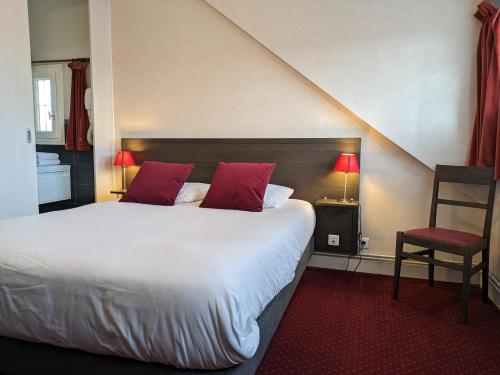 sypialnia z dużym łóżkiem z czerwonymi poduszkami w obiekcie Logis Hôtel Le Saint Florent w mieście Mont-près-Chambord