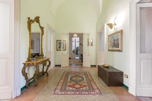 pasillo con espejo, mesa y alfombra en Dongiovanni Suite, en Lecce