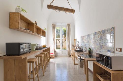 una cocina con encimeras de madera y taburetes de madera en Dongiovanni Suite, en Lecce