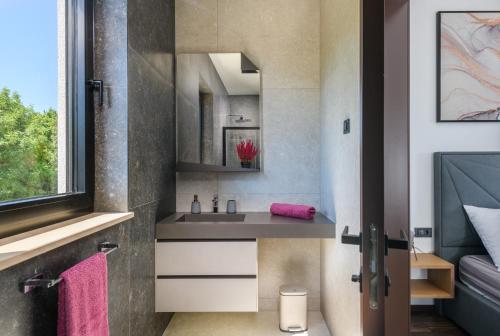 a bathroom with a sink and a mirror at Villa Abba Rakalj - Meerblick, Luxus und Komfort an der Südostküste Istriens in Rakalj