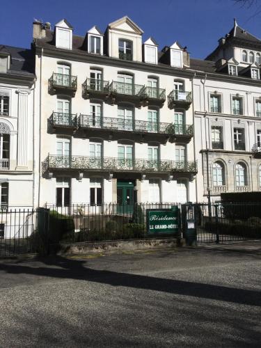 un gran edificio blanco con balcones y una valla en Appt entier rdc 1 chambre Allée d'Etigny en Luchon