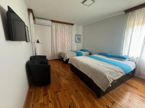 1 Schlafzimmer mit 2 Betten und einem Flachbild-TV in der Unterkunft GuestHouse Flora in Koper