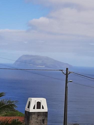 a building with a window on it next to the ocean at Casa vicente in Santa Cruz das Flores