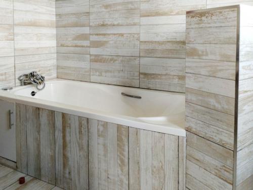 納紐基的住宿－Swara Ranch Nanyuki，带浴缸的浴室,设有木墙