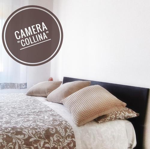 a bed with pillows and a sign that reads camera coluna at La Terrazza sul Reno - in pieno centro-due passi da Villa Chiara - comodo Unipol Arena in Casalecchio di Reno