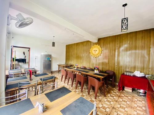 uma sala de jantar com mesas e cadeiras e um frigorífico em Hotel Hamta View Manali !! Top Rated & Most Awarded Property in Manali !! em Manali