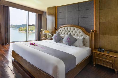 a bedroom with a large bed with a large window at Cat Ba Paradise Hotel- Pool & Sky Bar in Cat Ba