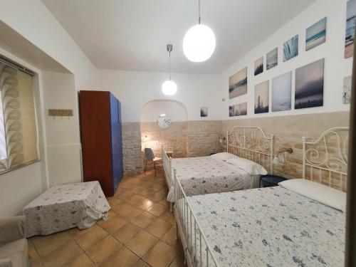 een slaapkamer met 3 bedden en een tafel en stoelen bij Trio D'Archi - La Maison de Cocò in Caltagirone