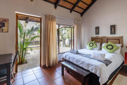 a bedroom with a bed and a large window at Ndumu River Lodge in Jozini