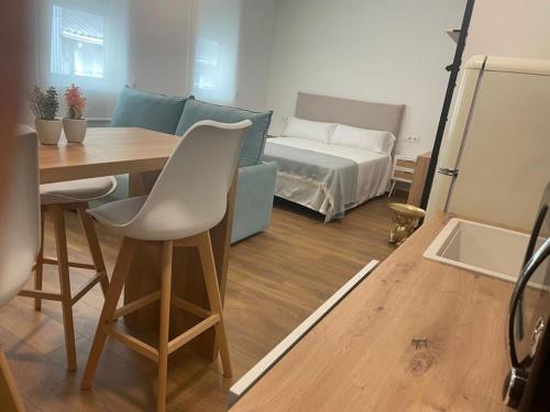 uma sala de estar com uma mesa e uma cama em Hostal Zahara em Ferrol