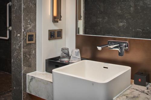 a bathroom with a white sink and a mirror at HUALUXE Kunshan Huaqiao by IHG - F1 Racing Preferred Hotel in Kunshan