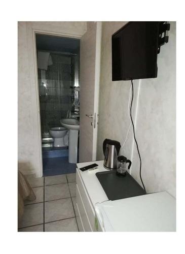 a kitchen with a refrigerator and a sink and a television at B & B AMICI DELL'ETNA in Nicolosi