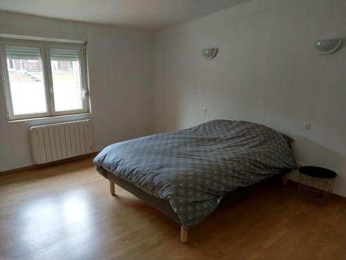 une chambre avec un lit dans une pièce avec une fenêtre dans l'établissement Agréable maison 2 ch 5 mins Valenciennes et garage, à Anzin