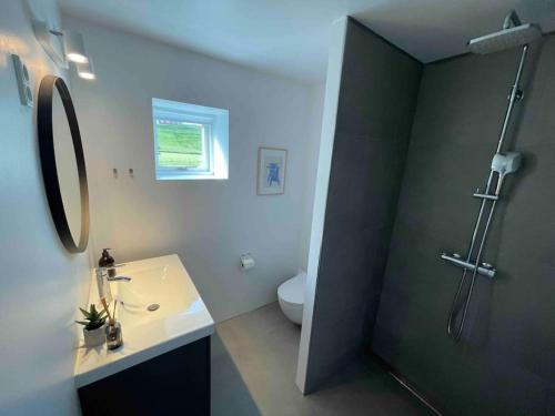 y baño con lavabo, aseo y ducha. en STAY-Atlantic en Skálavík