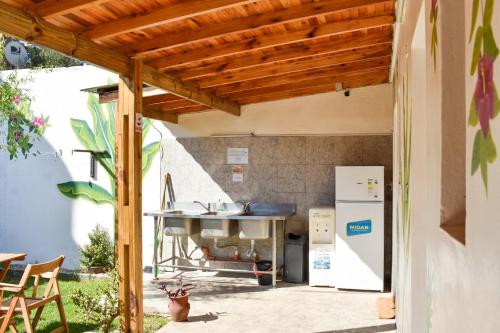 Colonia ChapadmalalDon Pototo Hospedaje Chapadmalal的一个带烧烤架和冰箱的户外厨房