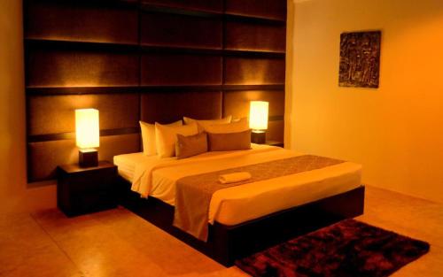 a bedroom with a large bed with two lamps at Sundari Eco Village in Habarana