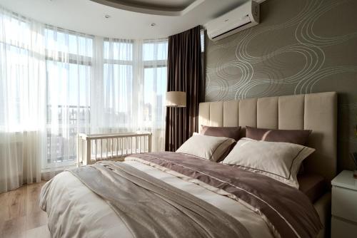 キーウにあるСozy Kiev Apartment str Chernovolaのベッドルーム1室(大きなベッド1台、大きな窓付)