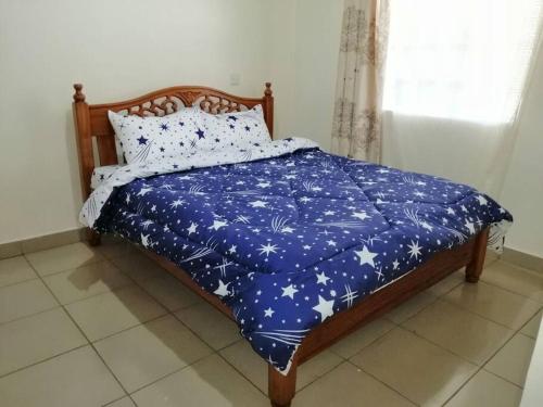 Una cama con una manta azul con estrellas. en Entire serviced 2-bedroom apartment in Thindigua, en Nairobi