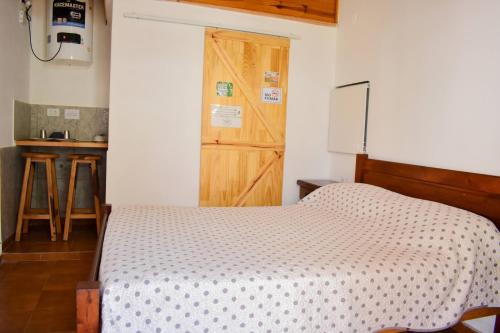 a bedroom with a bed and a wooden door at Don Pototo Hospedaje Chapadmalal in Colonia Chapadmalal