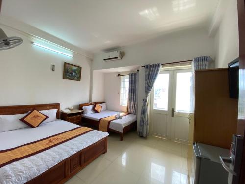 Habitación de hotel con 2 camas y sofá en Ngoc dung MoTel, en Vung Tau