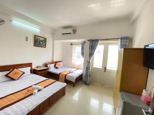 a hotel room with two beds and a tv at Ngoc dung MoTel in Vung Tau