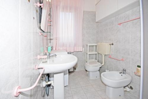 uma casa de banho com um lavatório e um WC em SABBIADORO em Cavallino-Treporti