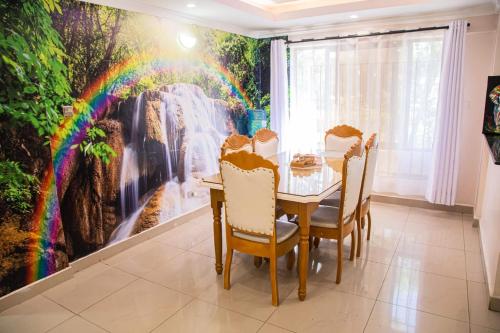 a dining room with a rainbow mural on the wall at Dylan Shawmutt Luxurious 3 Bedroom Apartment in Nakuru