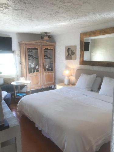 Le Bar-sur-LoupにあるMas Giroのベッドルーム(白い大型ベッド1台、キャビネット付)