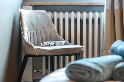 une paire de lunettes assise sur une chaise à côté d'un radiateur dans l'établissement Incantevole Appartamento in centro ad Alba, à Alba