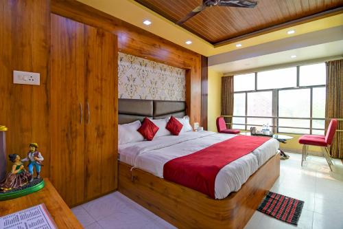 a bedroom with a large bed with red pillows at Hotel Ashray Near Temple & Beach By Morservices in Puri