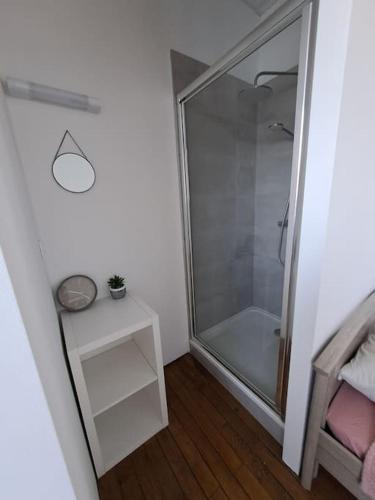 La salle de bains est pourvue d'une douche en verre et d'une table. dans l'établissement Studio à 15 min de Lille Flandres en TER pour 1 personne, à Armentières