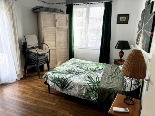 une chambre avec un lit, une table et une chaise dans l'établissement Appartement Sabatier T4 avec terrasse et jardin, à Carcassonne