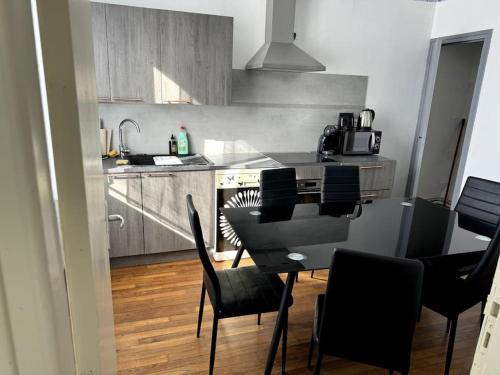 une cuisine avec une table et des chaises dans une cuisine dans l'établissement Appartement Sabatier T4 avec terrasse et jardin, à Carcassonne