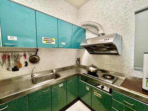 a kitchen with green cabinets and a sink at 澎湖菊舍民宿一館 in Magong