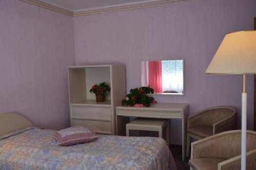 a bedroom with a bed and a table and a mirror at Ośrodek Wypoczynkowy Puszczyk Domek Akacjowy- Apartament -Willa in Sieraków