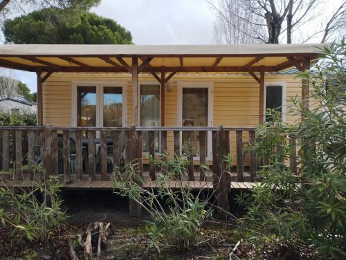 a tiny house with a porch and a deck at CAMPING L’ELYSÉE *** in Le Grau-du-Roi