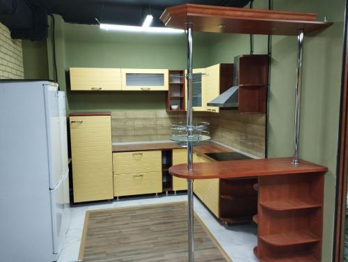 a kitchen with wooden cabinets and a refrigerator at KOCHEVNIK HOSTEL in Almaty