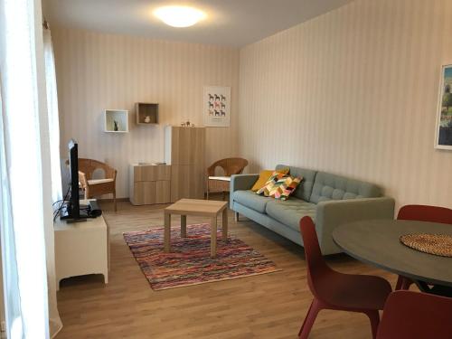 un salon avec un canapé et une table dans l'établissement LE MOMBRUN - Parking Privé - Hypercentre - Patio Intérieur, à Vichy