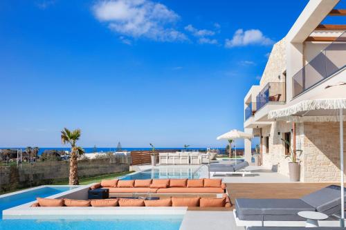 a villa with a swimming pool and the ocean at Vellis Residence in Stavromenos