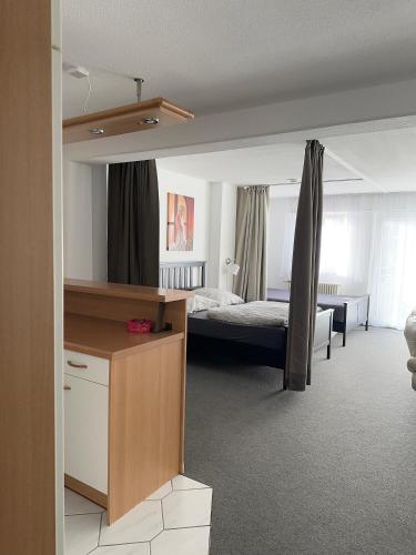 ein Schlafzimmer mit einem Bett und einem Schreibtisch in einem Zimmer in der Unterkunft Ferienwohnung Sonitschka in Lörrach