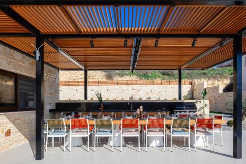 a patio with a table and chairs under a wooden ceiling at Vellis Residence in Stavromenos