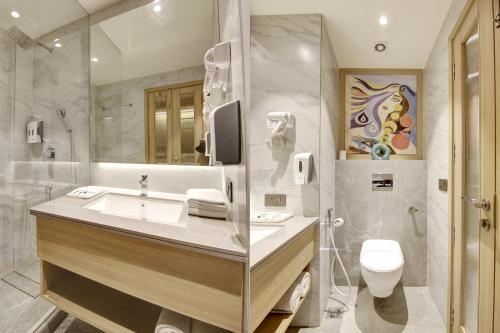 W łazience znajduje się umywalka, toaleta i prysznic. w obiekcie East Park Inn w Nowym Delhi