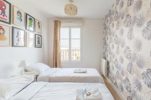 - une chambre avec 2 lits et un mur avec des photos dans l'établissement Cosy Proche Disneyland Paris, à Serris