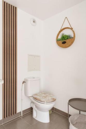 La salle de bains est pourvue de toilettes et d'un panier mural. dans l'établissement Cosy Proche Disneyland Paris, à Serris