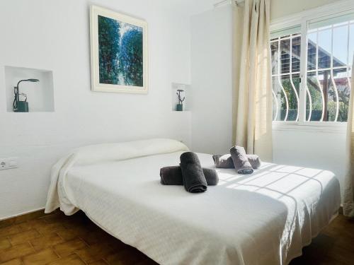 two beds in a white bedroom with a window at Villa Sol i Mar by Costabravaway in Platja  d'Aro