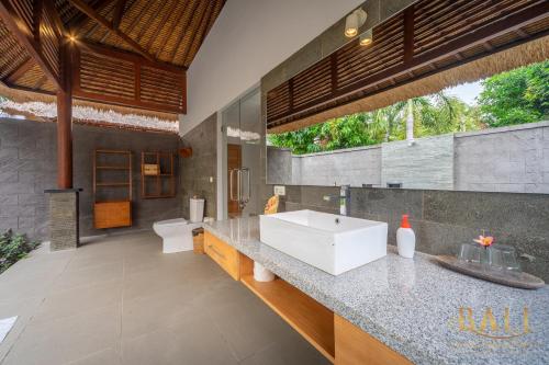 uma casa de banho com um lavatório branco e uma grande janela em DeLuxe 2BR Villa with, Sawa view and private pool! em Tegallengah